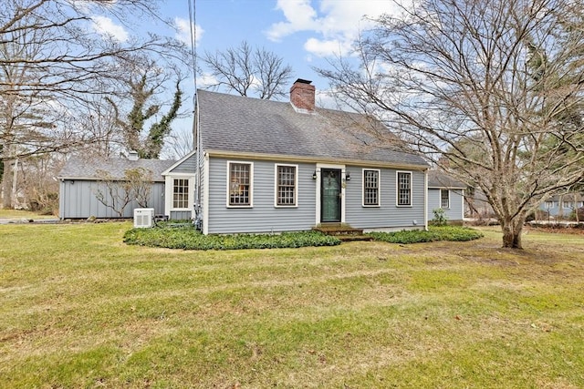 cape cod house with entry steps, roof with shingles, a chimney, and a front yard