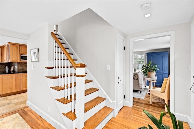 stairway with baseboards and hardwood / wood-style floors