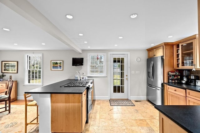 kitchen with dark countertops, glass insert cabinets, stainless steel appliances, and recessed lighting