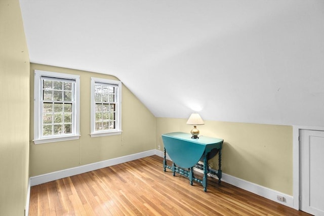 bonus room featuring lofted ceiling, wood-type flooring, and baseboards