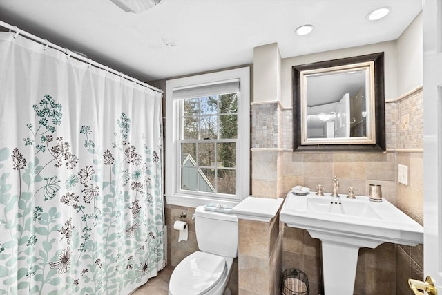 bathroom with visible vents, a shower with shower curtain, tile walls, and toilet