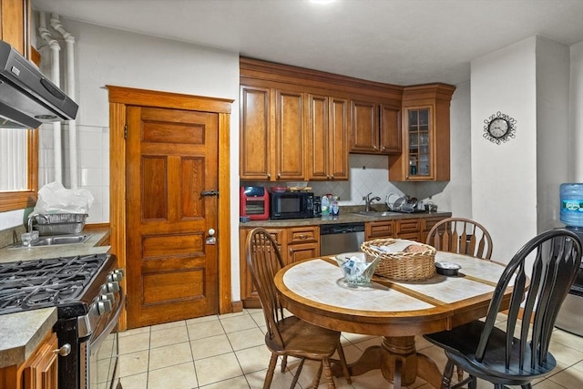 kitchen featuring tasteful backsplash, sink, stainless steel appliances, wall chimney exhaust hood, and light tile patterned flooring