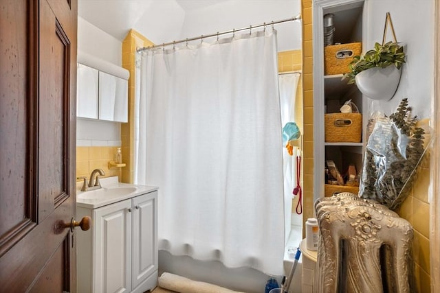 bathroom with tasteful backsplash, shower / bath combination with curtain, and vanity