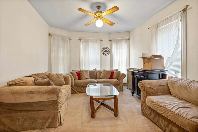 living room with light colored carpet, a wealth of natural light, and ceiling fan