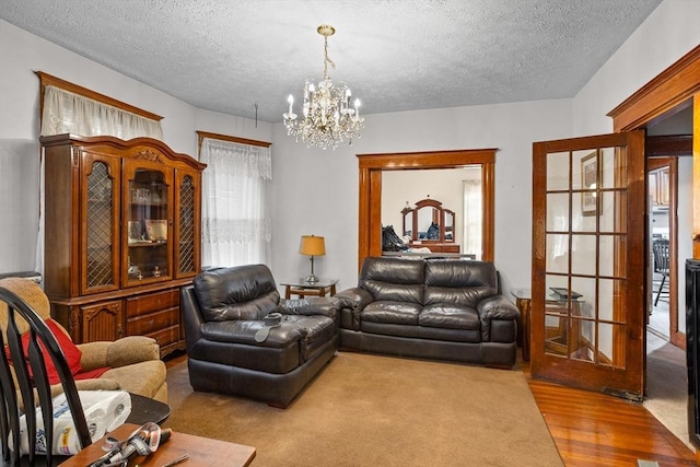 carpeted living room featuring a notable chandelier and a textured ceiling