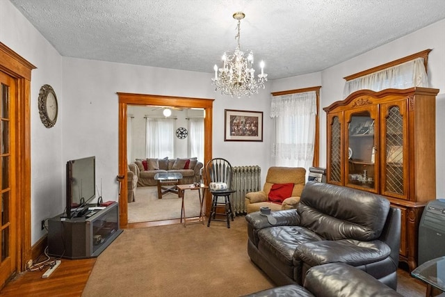 living room with a chandelier, radiator heating unit, hardwood / wood-style floors, and a textured ceiling