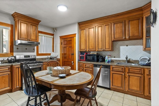 kitchen featuring sink, backsplash, stainless steel appliances, and light tile patterned flooring