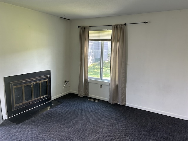 unfurnished living room featuring dark colored carpet