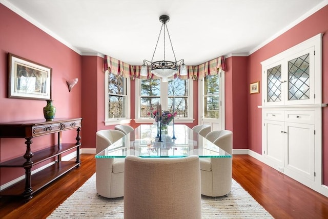 dining area with a chandelier, dark wood-type flooring, and baseboards