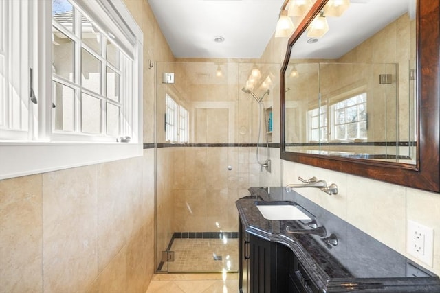 full bathroom featuring tile walls, a shower stall, and vanity