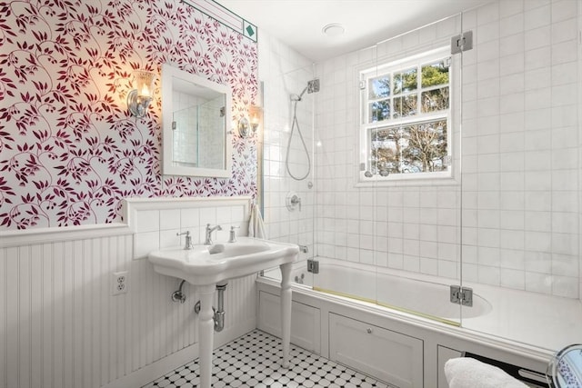 full bathroom featuring wallpapered walls, enclosed tub / shower combo, and wainscoting