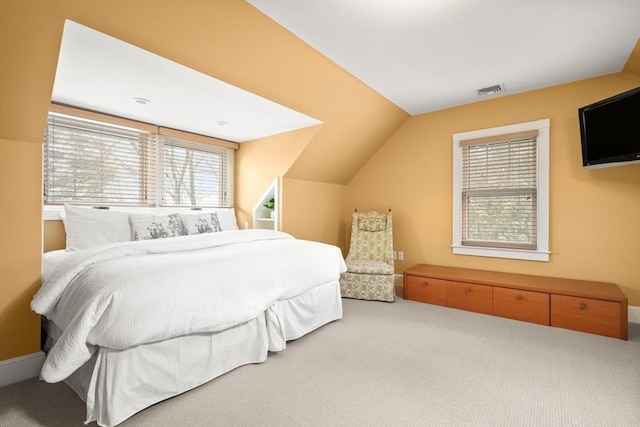 carpeted bedroom featuring lofted ceiling and visible vents