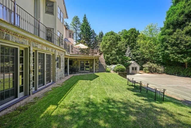 view of yard featuring stairs, an outdoor structure, and a wooden deck