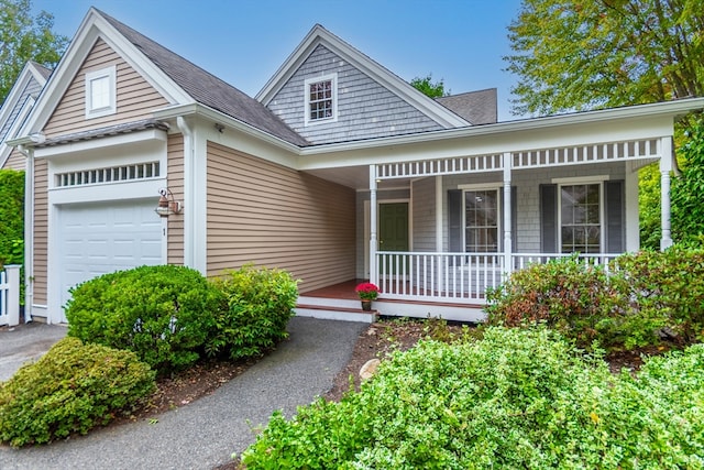 view of front property with a porch and a garage