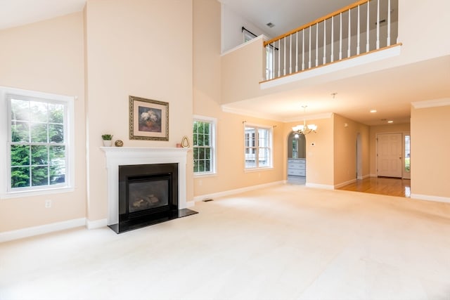 unfurnished living room with carpet flooring, a wealth of natural light, crown molding, and high vaulted ceiling