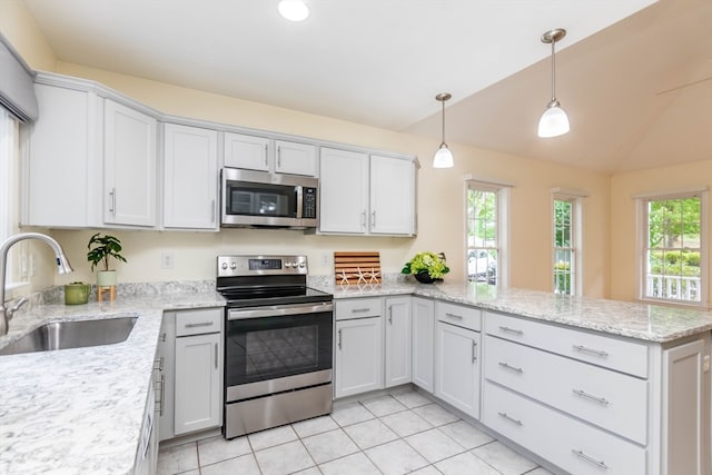 kitchen featuring kitchen peninsula, appliances with stainless steel finishes, vaulted ceiling, sink, and white cabinetry