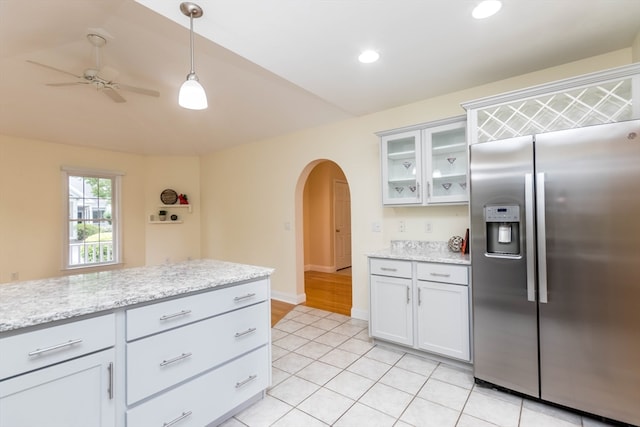 kitchen with stainless steel built in refrigerator, ceiling fan, light stone countertops, decorative light fixtures, and white cabinetry