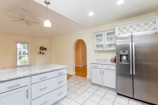 kitchen featuring light stone countertops, stainless steel fridge with ice dispenser, light hardwood / wood-style flooring, vaulted ceiling, and gray cabinets