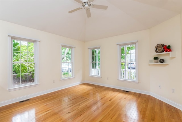 unfurnished room with ceiling fan, a healthy amount of sunlight, light hardwood / wood-style floors, and vaulted ceiling