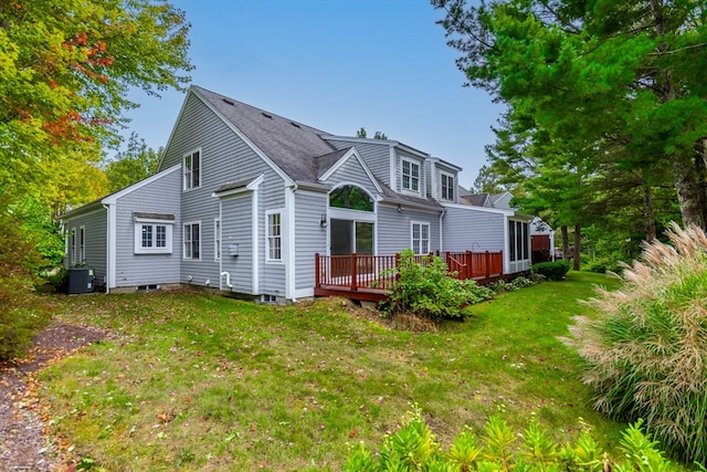 rear view of property featuring a deck, cooling unit, and a lawn