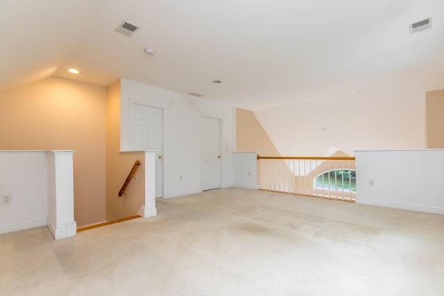 additional living space with light colored carpet and vaulted ceiling