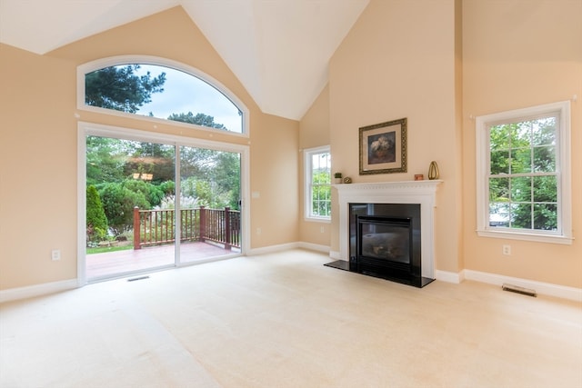 unfurnished living room with light carpet and high vaulted ceiling