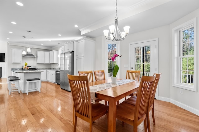 dining room with a chandelier, light hardwood / wood-style floors, and ornamental molding