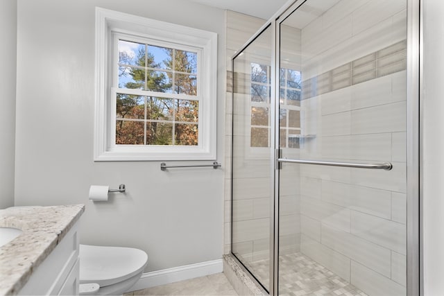 bathroom featuring tile patterned floors, vanity, toilet, and an enclosed shower