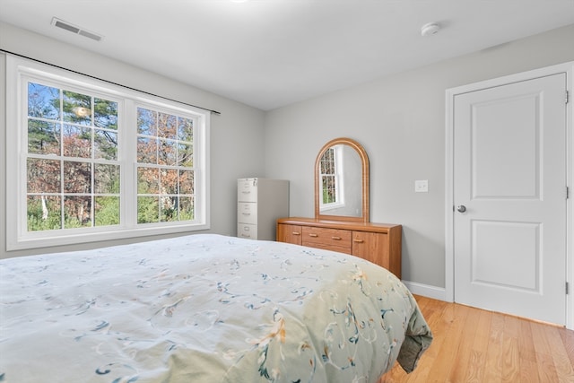 bedroom with multiple windows and light wood-type flooring