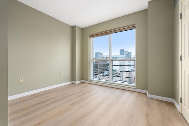 1 Nassau St Unit 2105, Boston, MA 02111 - empty room featuring a view of city, light wood-style flooring, and baseboards
