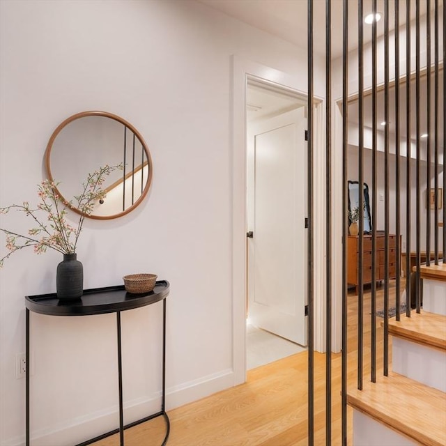 hallway with light wood-type flooring and baseboards