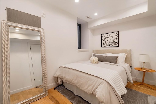 bedroom featuring light wood finished floors, recessed lighting, visible vents, and baseboards