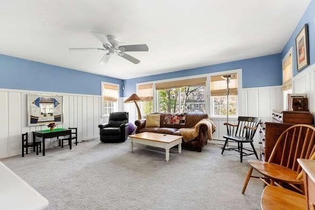 living room with ceiling fan, a decorative wall, and carpet flooring