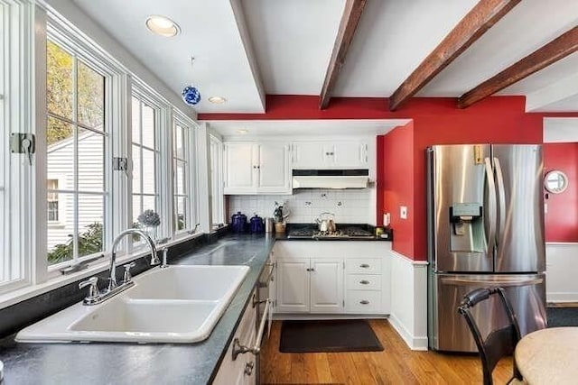 kitchen featuring a sink, dark countertops, stainless steel appliances, and under cabinet range hood
