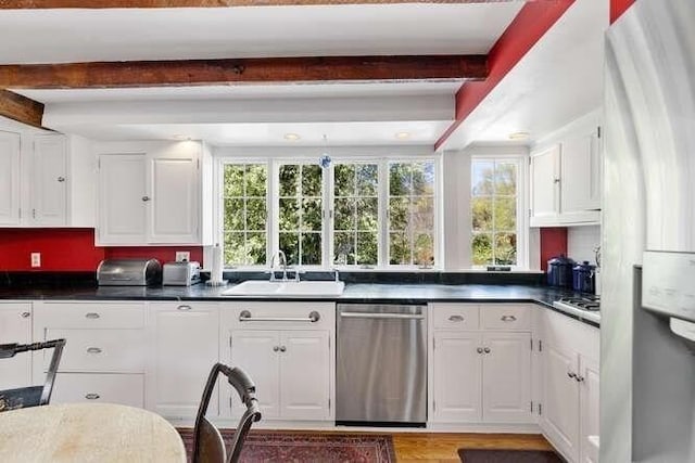 kitchen featuring a sink, beamed ceiling, a wealth of natural light, and stainless steel appliances