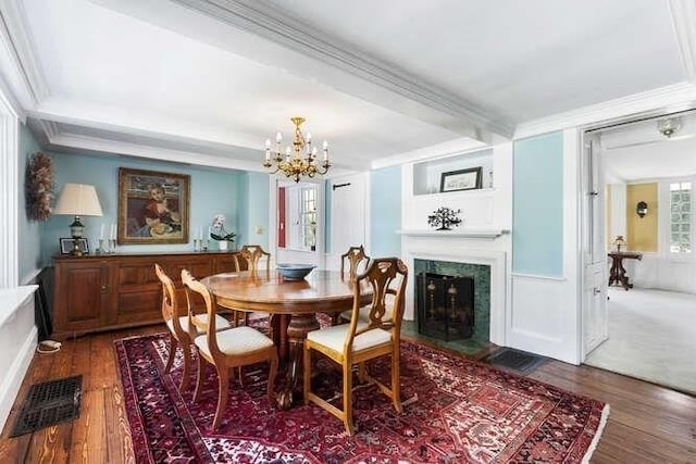 dining room featuring a chandelier, visible vents, ornamental molding, and wood finished floors