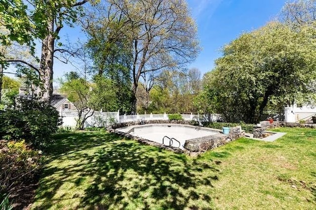 view of community with a fenced backyard and a lawn