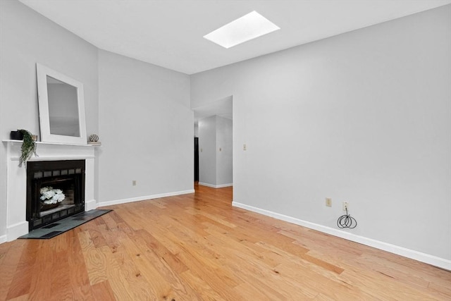 51 Nottingham Rd Unit 51, Grafton, MA 01519 - unfurnished living room featuring a skylight, a fireplace, and wood finished floors
