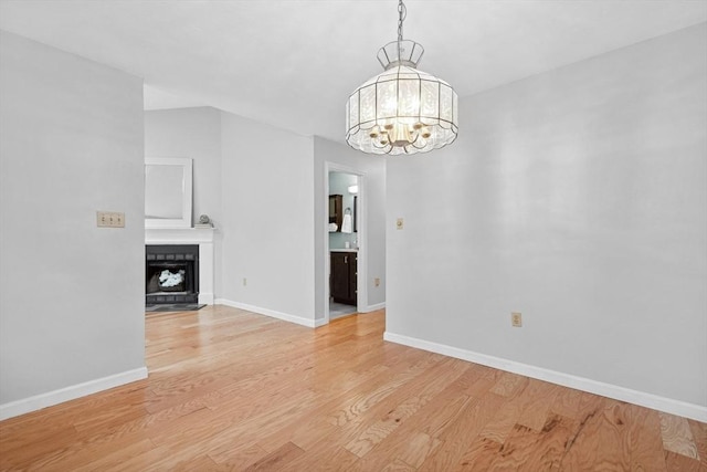 51 Nottingham Rd Unit 51, Grafton, MA 01519 - spare room with light wood-style flooring, a chandelier, and a fireplace with flush hearth