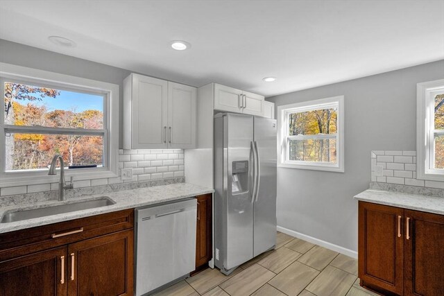 531 Old N Rd, Worthington, MA 01098 - kitchen featuring stainless steel appliances, a sink, backsplash, light stone countertops, and white cabinets
