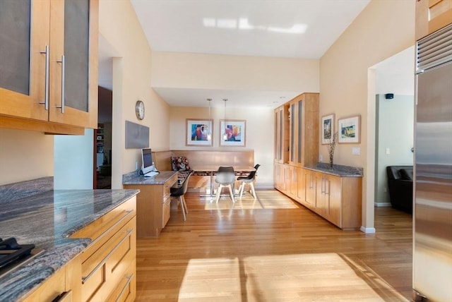 kitchen featuring glass insert cabinets, light wood-style floors, and built in fridge