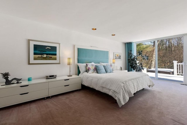 bedroom with floor to ceiling windows, dark carpet, and access to outside