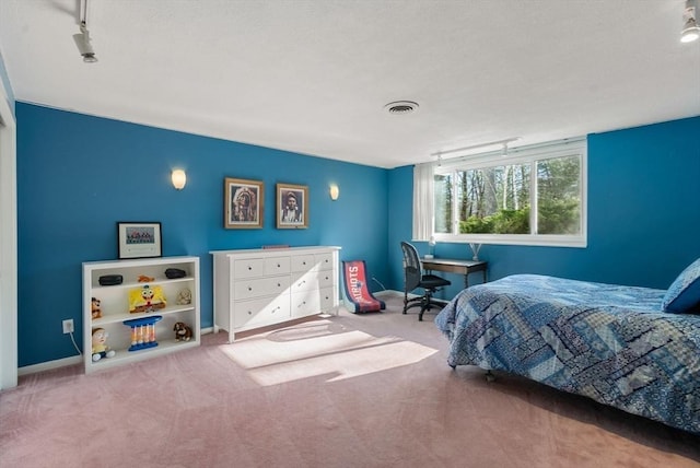 bedroom with visible vents, carpet floors, baseboards, and rail lighting