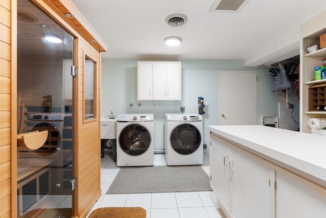 laundry room with washer and dryer, light tile patterned floors, cabinet space, and visible vents