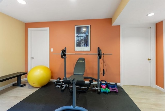 workout area with recessed lighting, baseboards, and wood finished floors