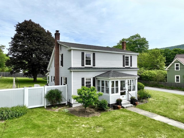 12 Wellington St, Buckland, MA 01370 - view of front of house featuring a chimney, entry steps, a sunroom, and roof with shingles