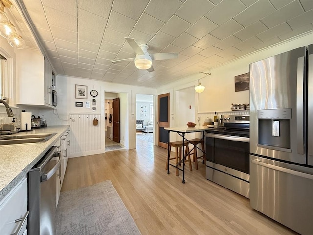 12 Wellington St, Buckland, MA 01370 - kitchen featuring appliances with stainless steel finishes, a sink, ceiling fan, light wood-style flooring, and white cabinets