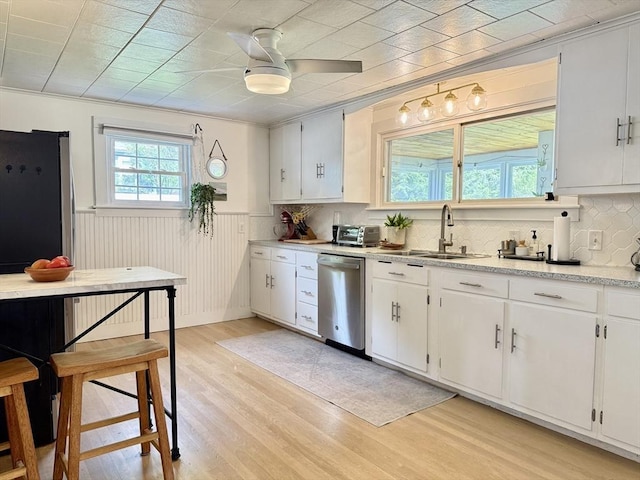 12 Wellington St, Buckland, MA 01370 - kitchen featuring appliances with stainless steel finishes, a sink, light wood-type flooring, light countertops, and wainscoting