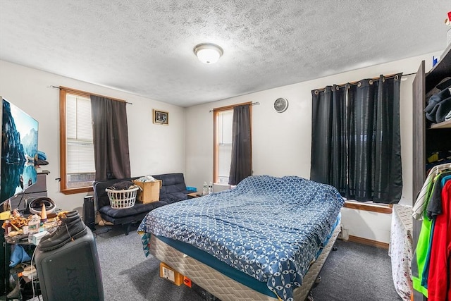 bedroom featuring carpet floors, baseboards, and a textured ceiling