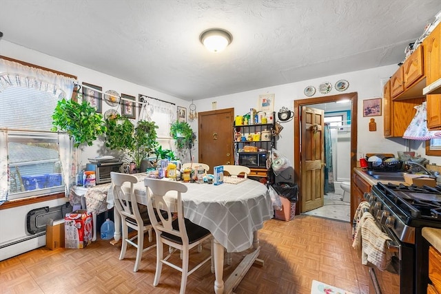 dining area with a baseboard radiator and a textured ceiling